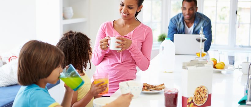 Family Having Breakfast In Kitchen Together