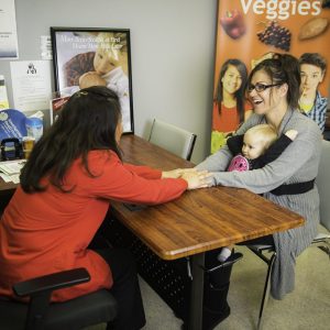 mom and child with woman at desk