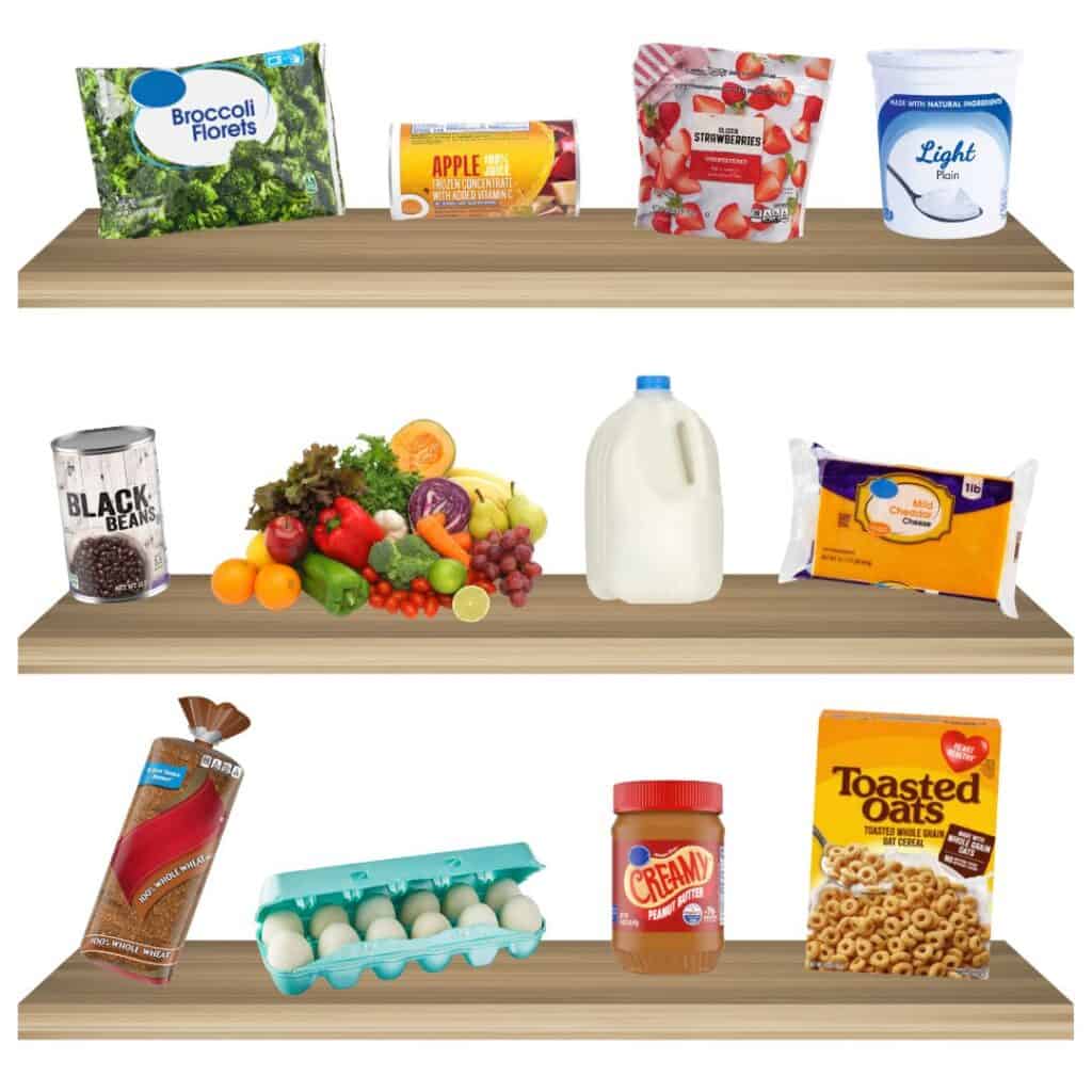 Tres estantes de madera exhiben diversos alimentos: brócoli congelado, jugo de manzana, yogur, bayas mixtas, frijoles negros, productos frescos, leche, queso cheddar, pan, huevos, mantequilla de maní y cereales.